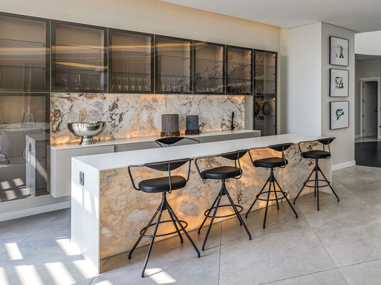 Custom bar island with black bar stools, stone counter top and stone wall cladding by Trend Stone