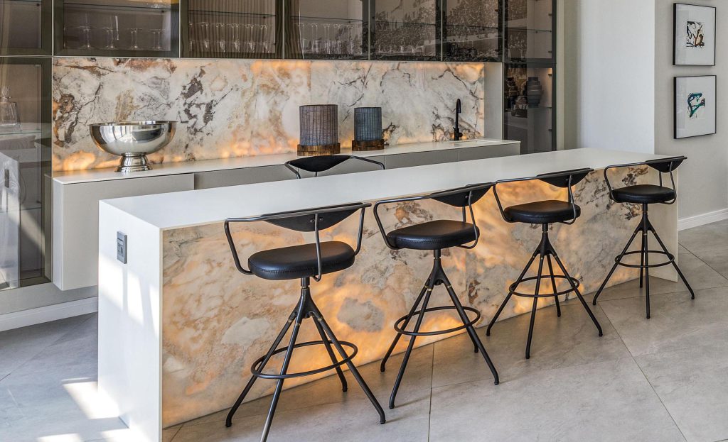 Custom bar island with black bar stools, stone counter top and stone wall cladding by Trend Stone